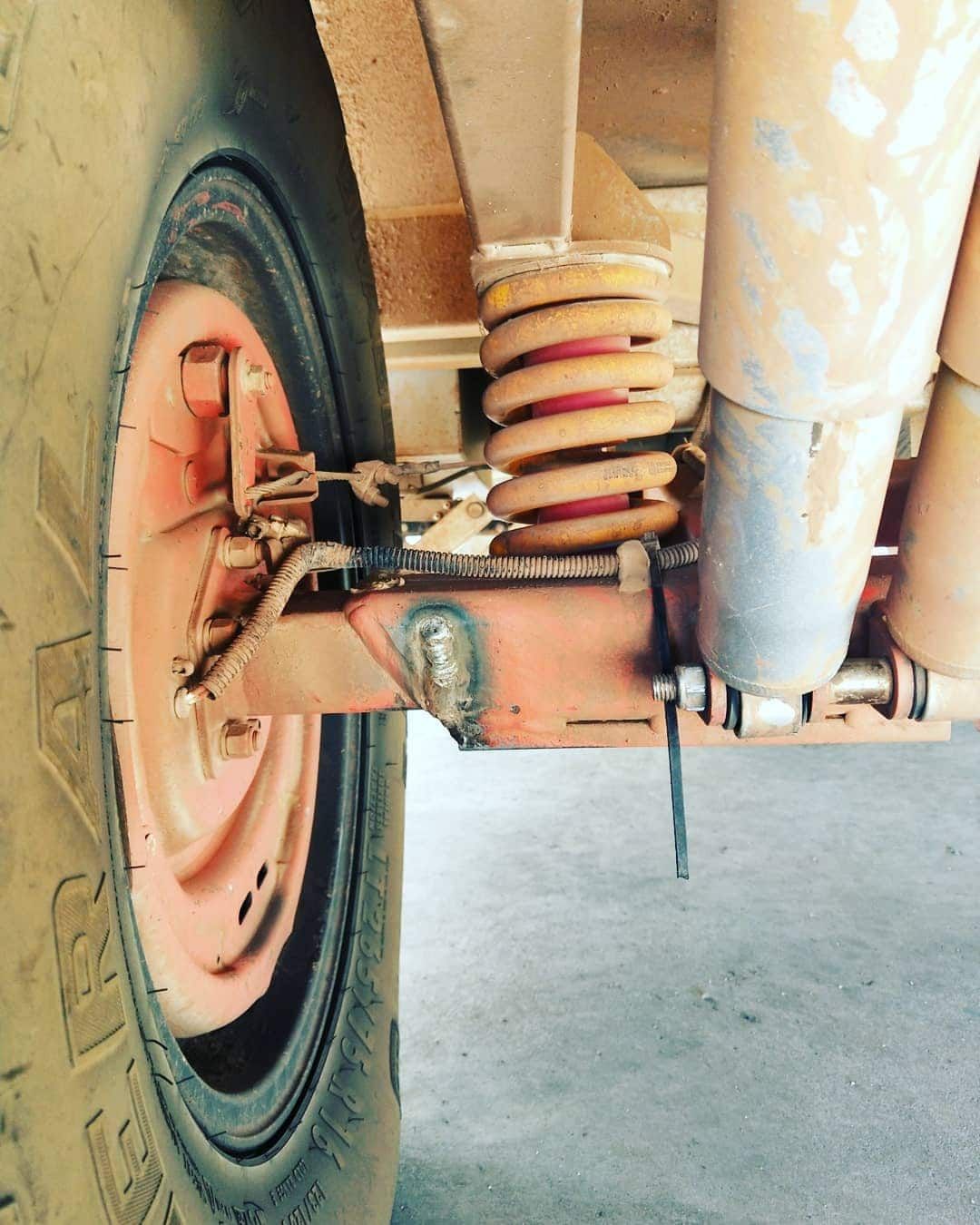 Close-up of a Rusty Red Trailer Wheel With a Spring — Boycey's Custom Engineering in Atherton, QLD
