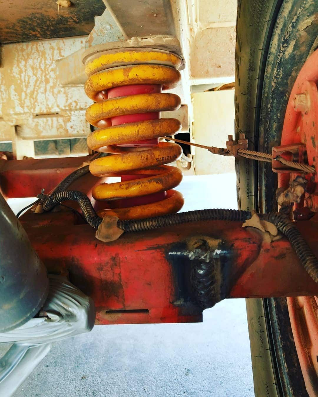 Yellow Coil Spring and Red Frame on a Vehicle's Suspension — Boycey's Custom Engineering in Atherton, QLD