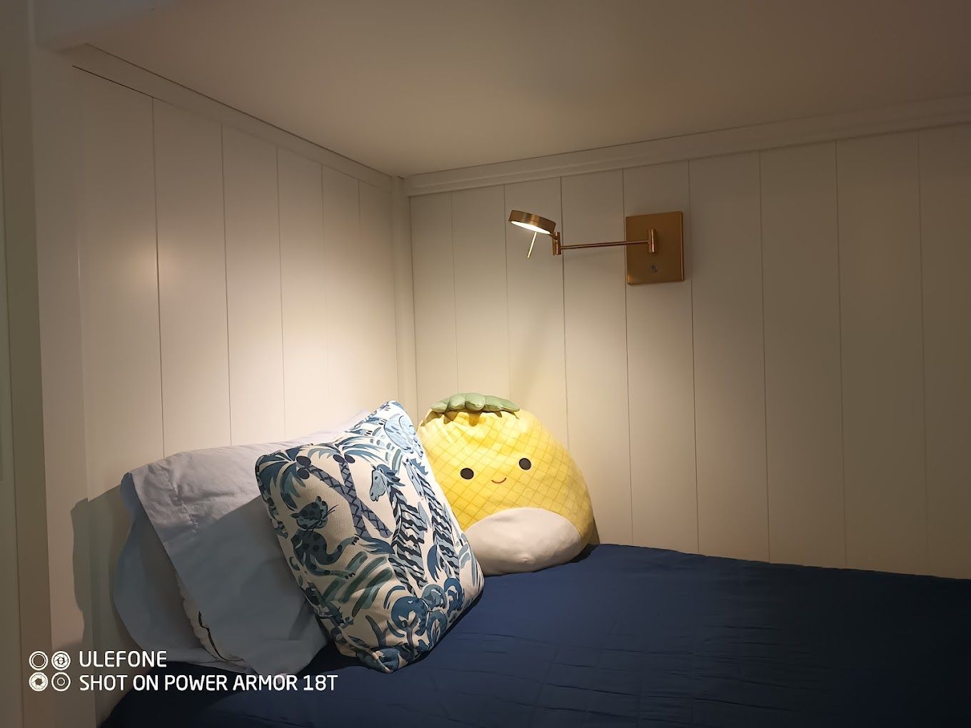 A bed with pillows and a stuffed animal on it in a bedroom.