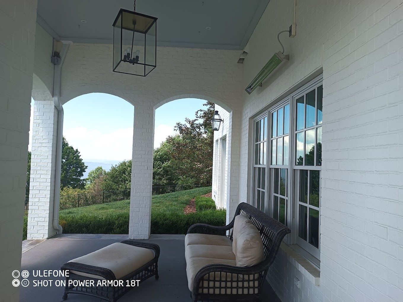 A porch with a couch and a chaise lounge on it