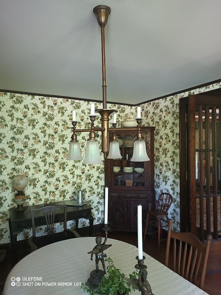 A dining room with a table and chairs and a chandelier hanging from the ceiling.