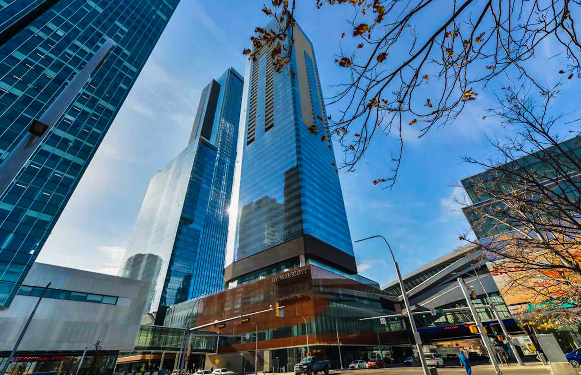 2 Blue glass towers on a sunny day on a busy street