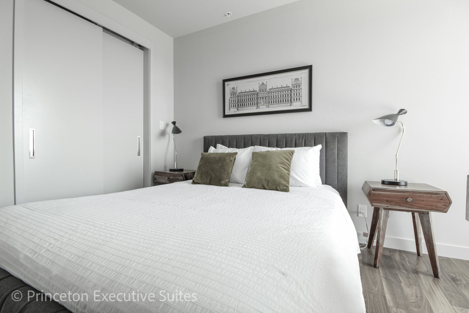 White luxurious bed in master bedroom of this edmonton furnished apartment
