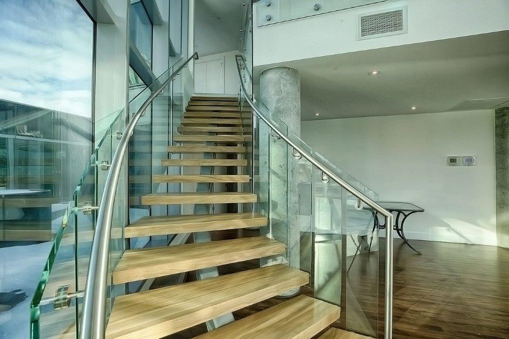 Light collared door and glass winding staircase going up stairs to in the elegant social room