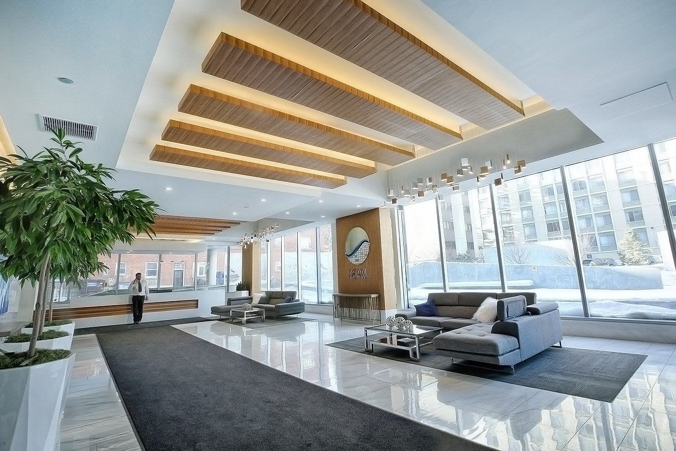 Majestic white marble grand lobby wiht vaulted wood and marble ceiling concierge desk in the back ground with concierge service in this edmonton executive suite