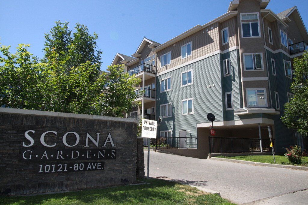 Front driveway with Scona Gardens Sign and address . The blue and gray building in the background