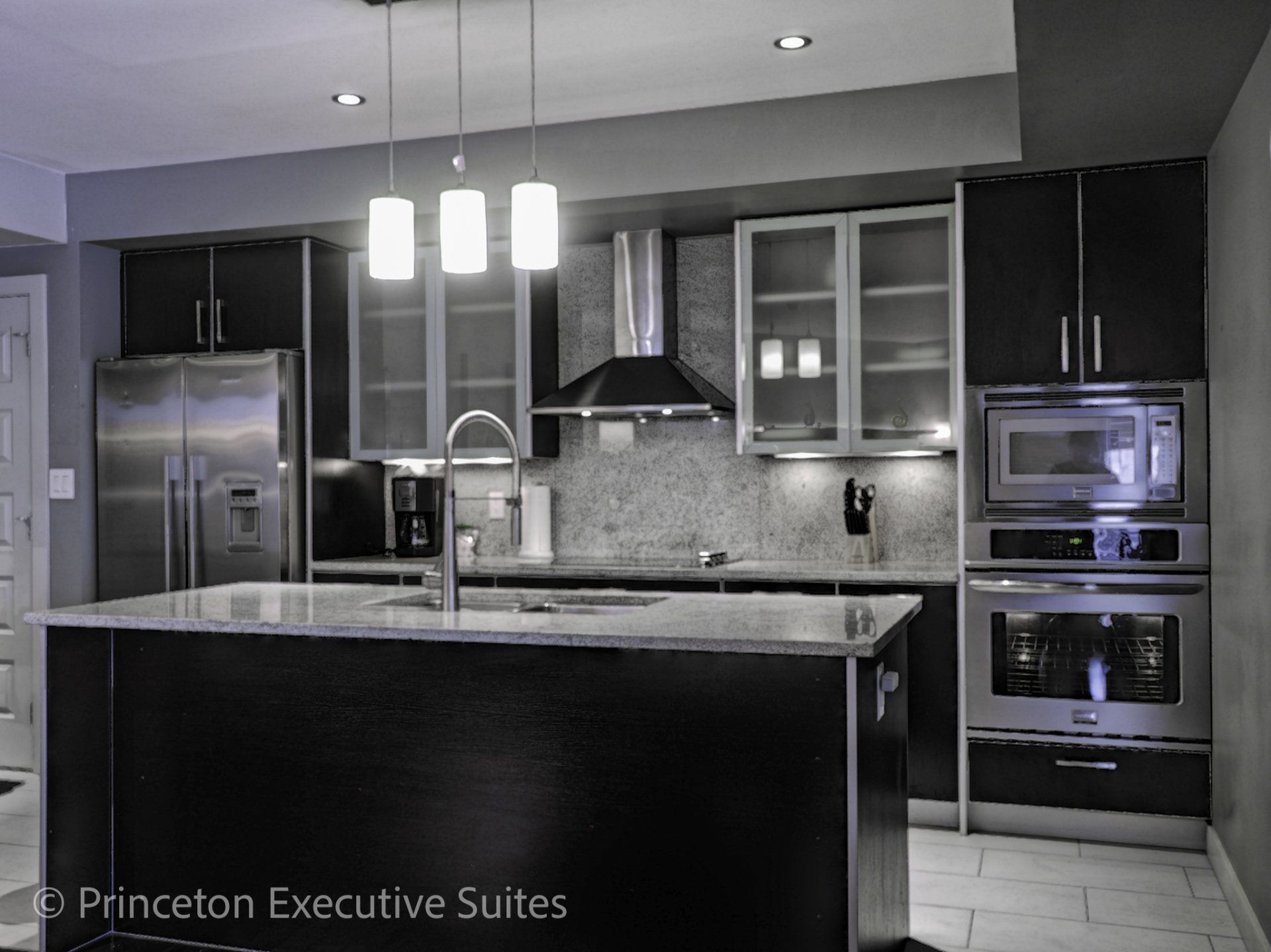 Kitchen area with black countertops in a Edmonton luxury suite