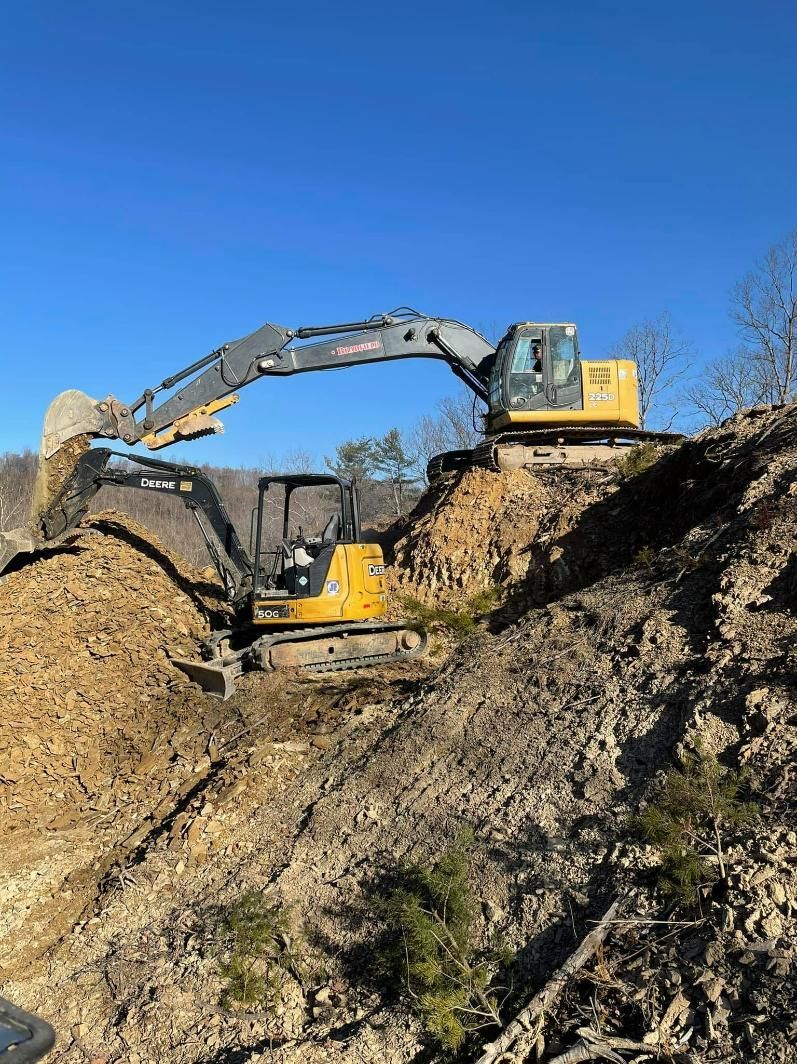 A bulldozer is moving dirt on top of a hill.