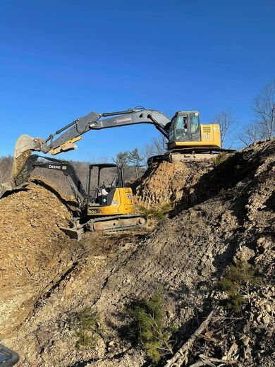 A bulldozer is moving dirt on top of a hill.
