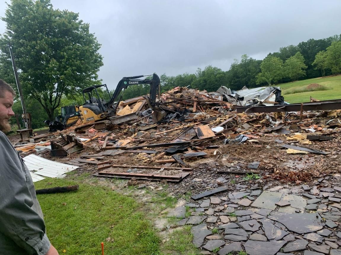 A man is standing in front of a pile of rubble.
