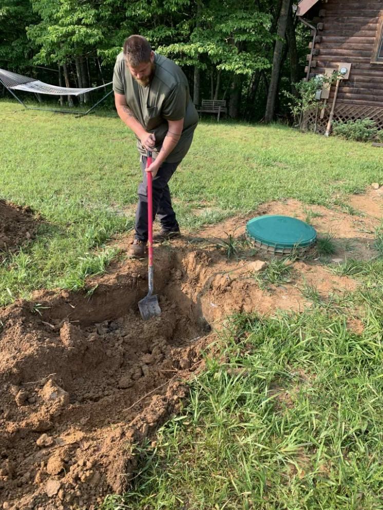 A man is digging a hole in the ground with a shovel.