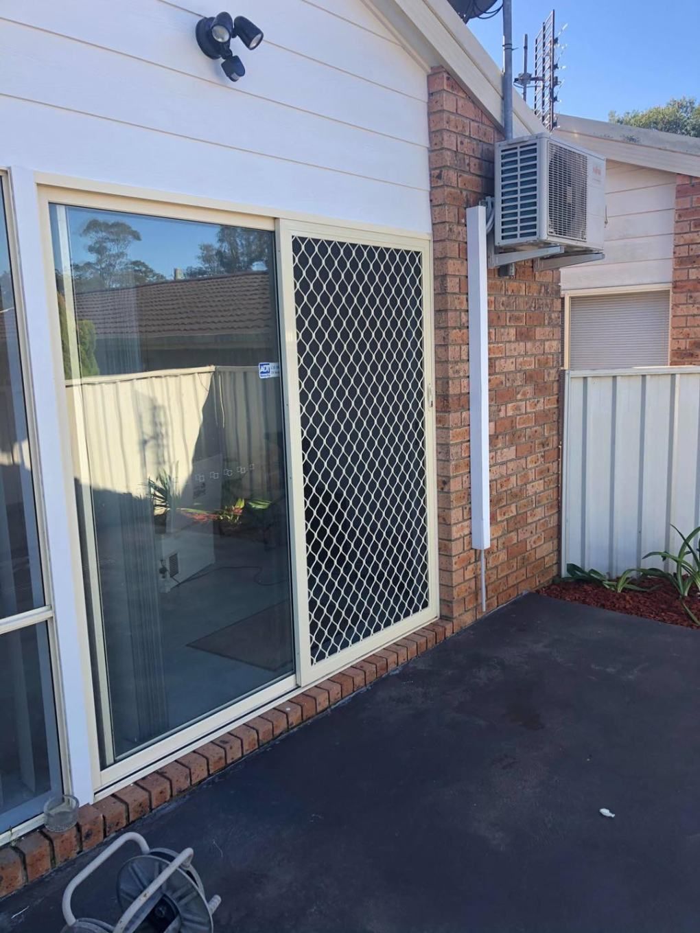 There Is A Sliding Glass Door On The Side Of A House — Central Coast Flyscreen Service In West Gosford, NSW