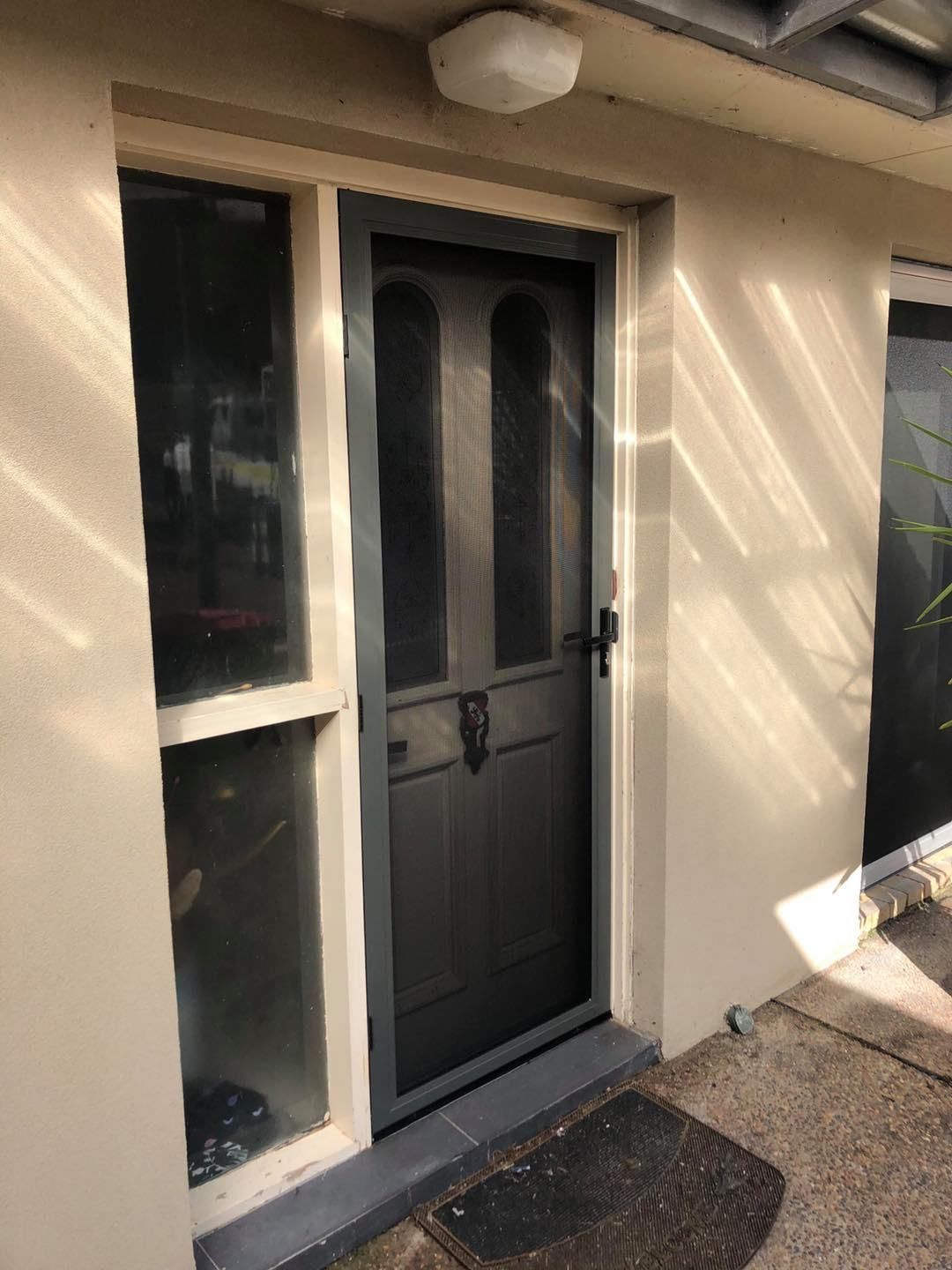 A Door With A Screen On It Is On The Side Of A House — Central Coast Flyscreen Service In Woy Woy, NSW