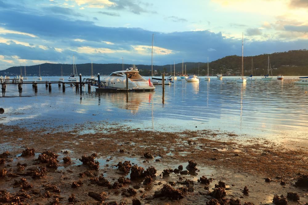 A Boat Is Docked In The Water Near A Dock — Central Coast Flyscreen Service In West Gosford, NSW
