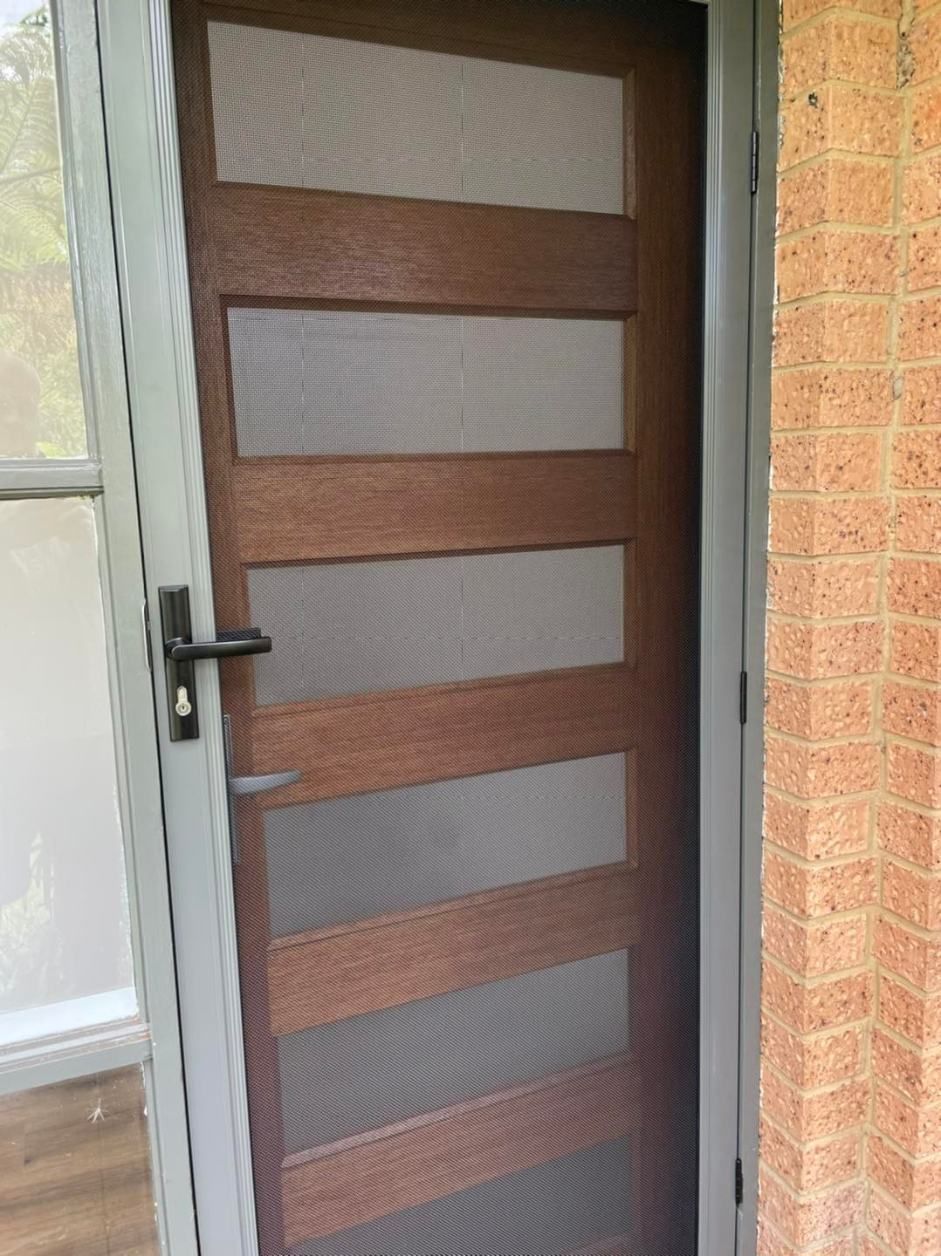 A Wooden Screen Door With A Brick Wall In The Background — Central Coast Flyscreen Service In Wyee, NSW