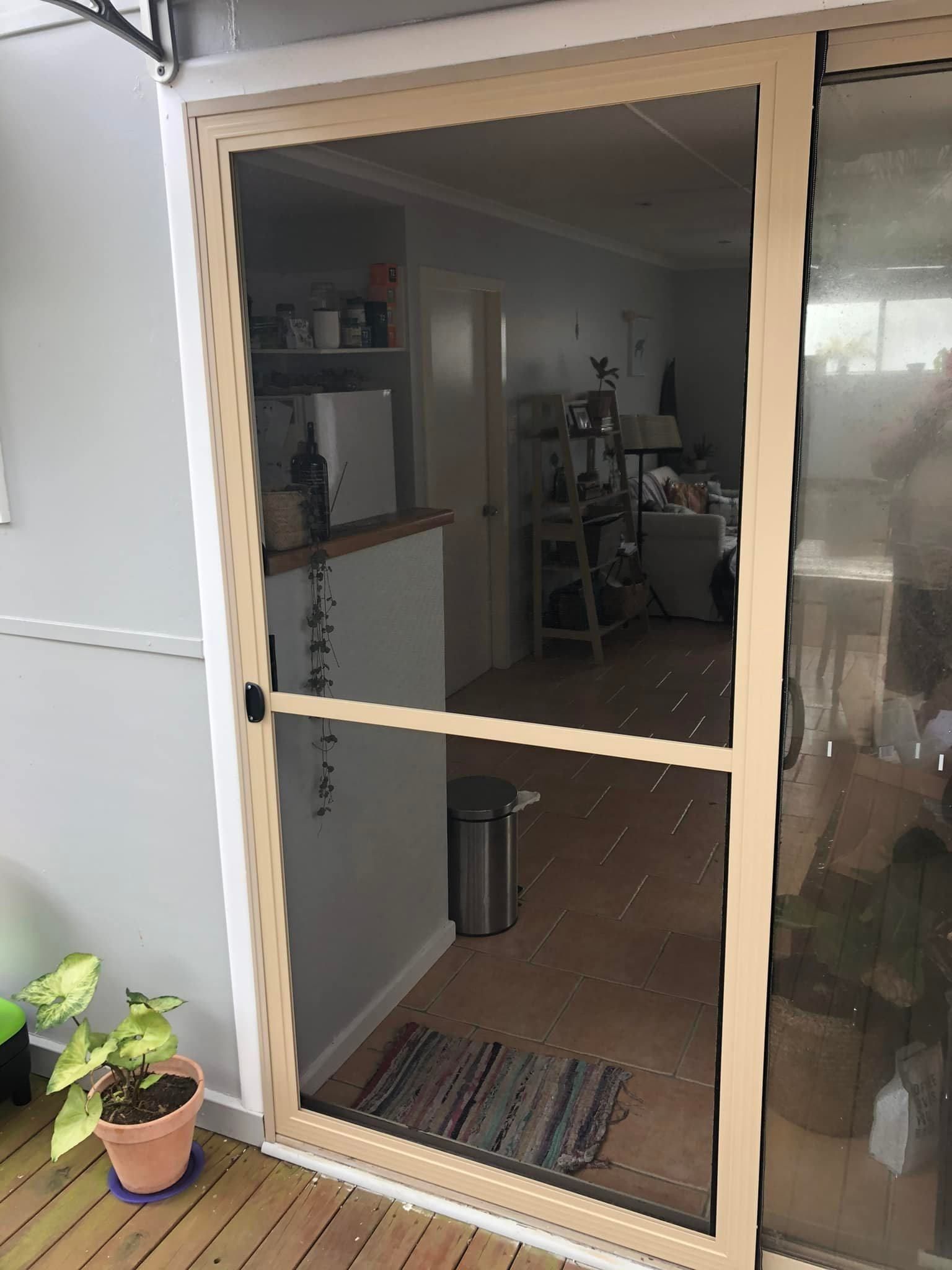 A Screen Door Is Open To A Living Room In A House — Central Coast Flyscreen Service In Wyee, NSW