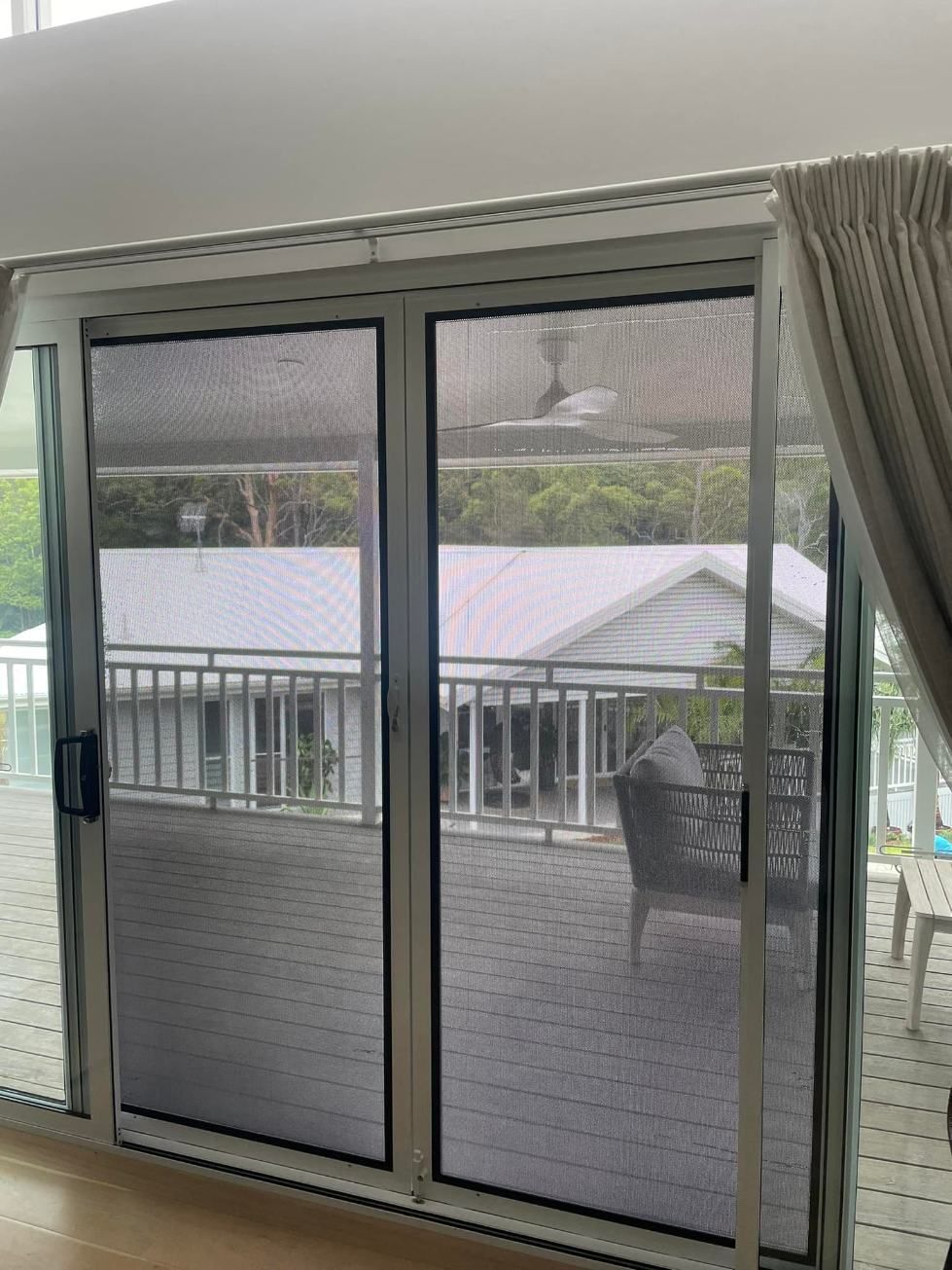 A Living Room With A Sliding Glass Door Leading To A Balcony — Central Coast Flyscreen Service In Warnervale, NSW