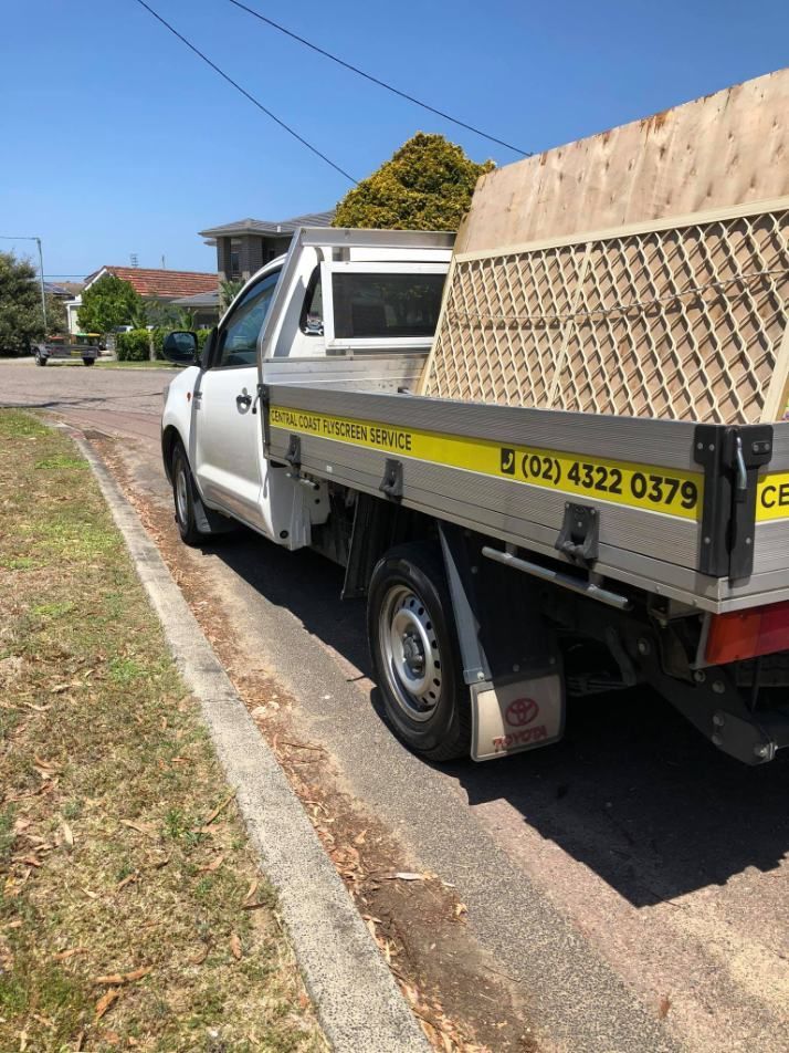 A White Truck Is Parked On The Side Of The Road — Central Coast Flyscreen Service In West Gosford, NSW