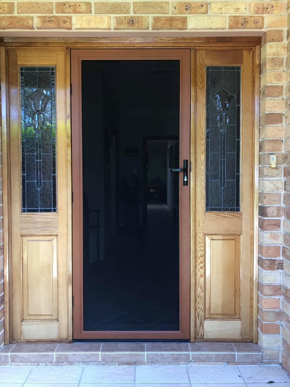 A Wooden Door With A Screen On It Is In Front Of A Brick Wall — Central Coast Flyscreen Service In Wyee, NSW