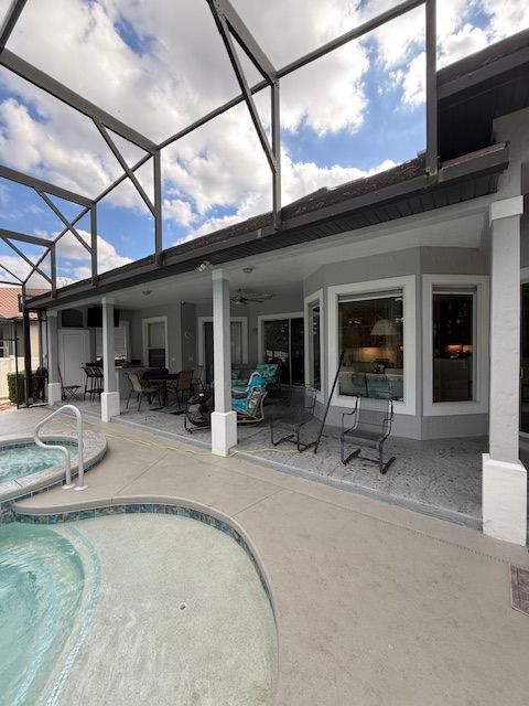 White-framed window with blinds, on a textured tan wall, above brick paving.