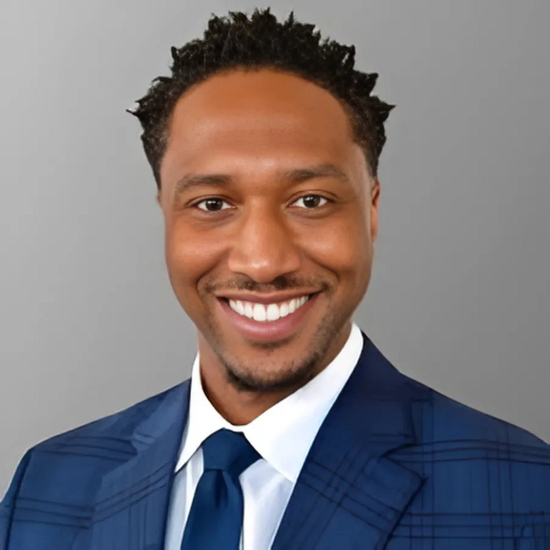 A man in a suit and tie is smiling for the camera