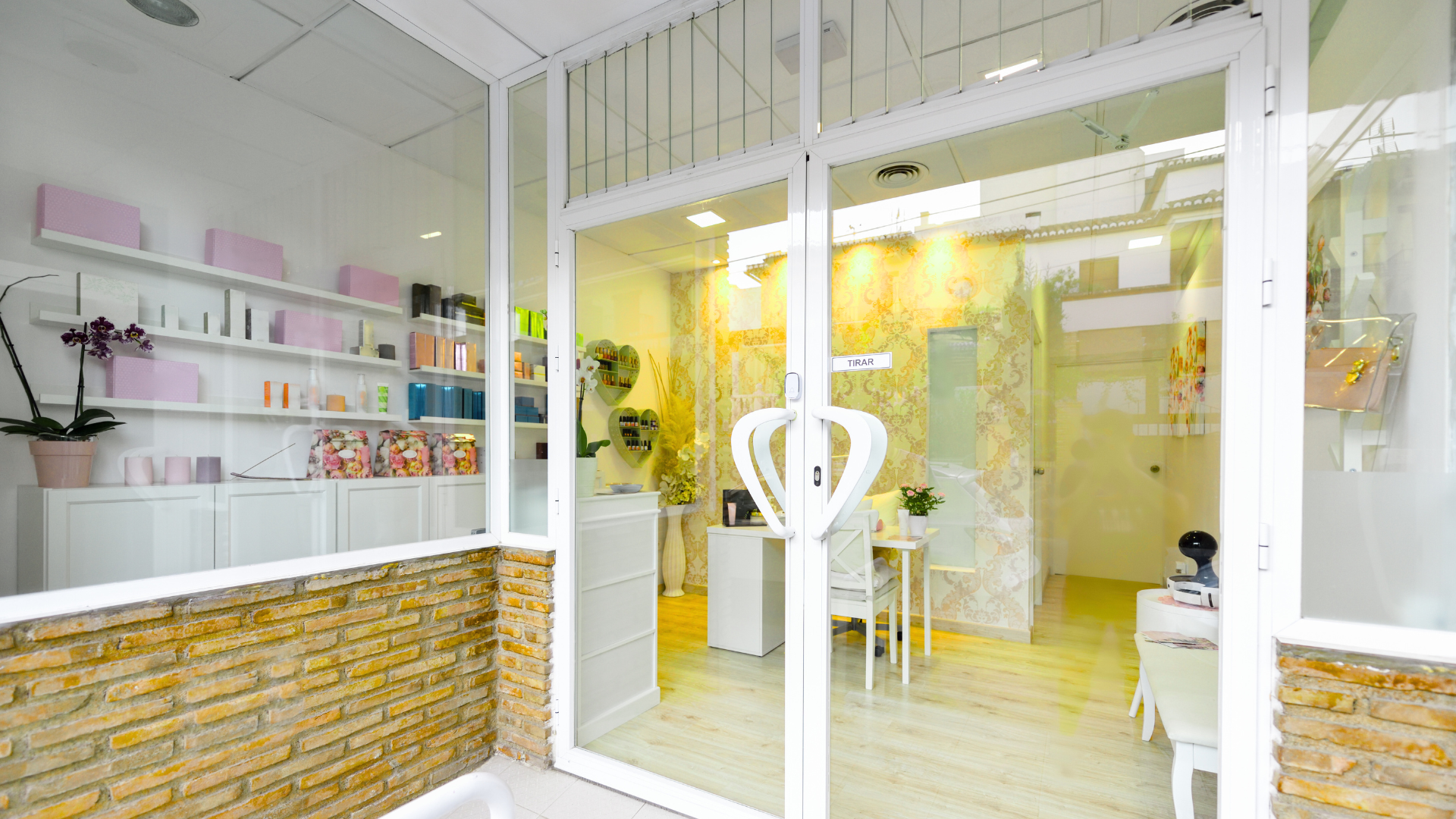 A store front with a large glass door and a brick wall.