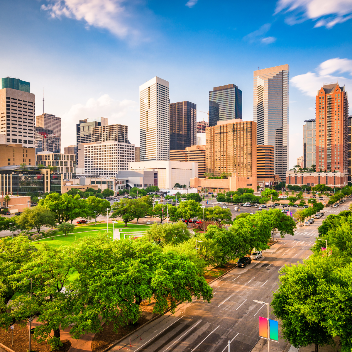 An aerial view of a city skyline with a park in the foreground.