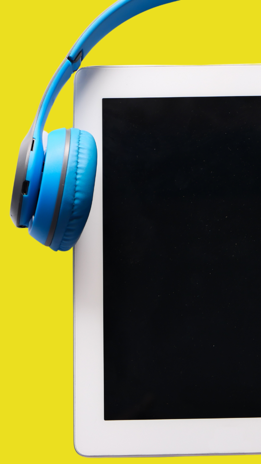 A pair of blue headphones sitting on top of a tablet.