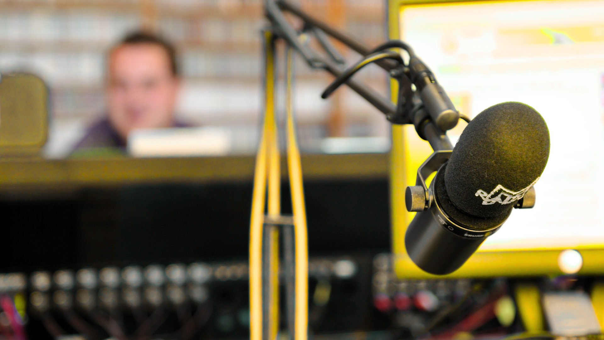 A close up of a microphone with a man in the background
