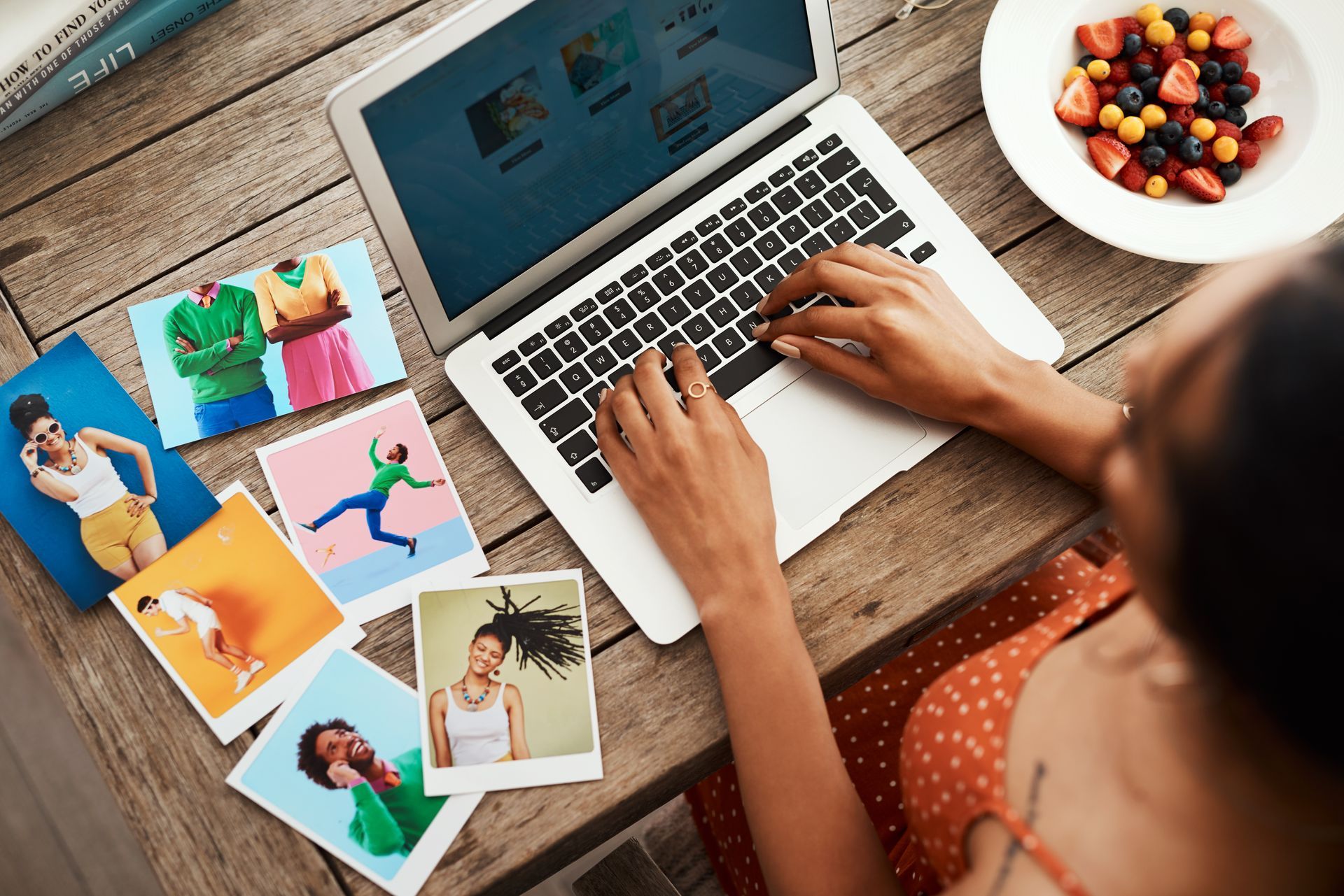 A woman is sitting at a table using a laptop computer.