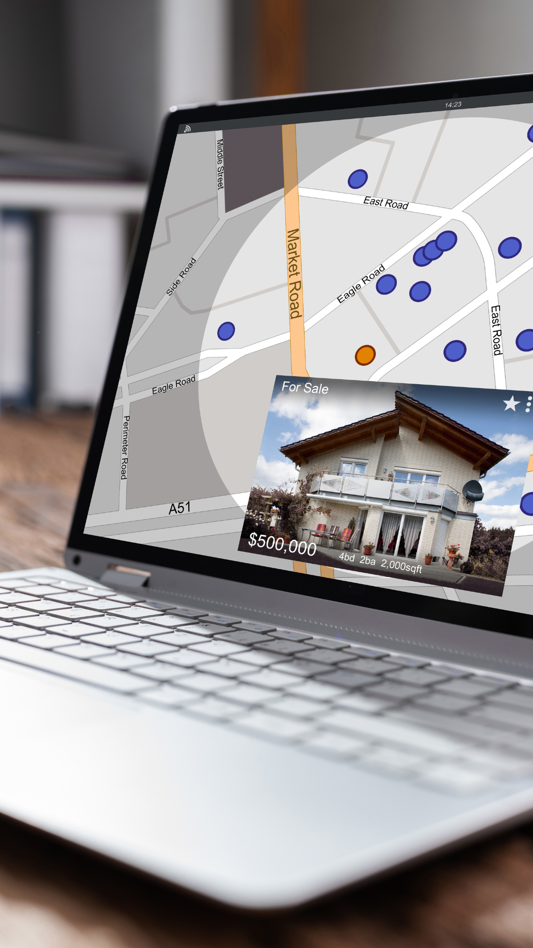 A laptop computer is open to a map and a picture of a house on the screen.