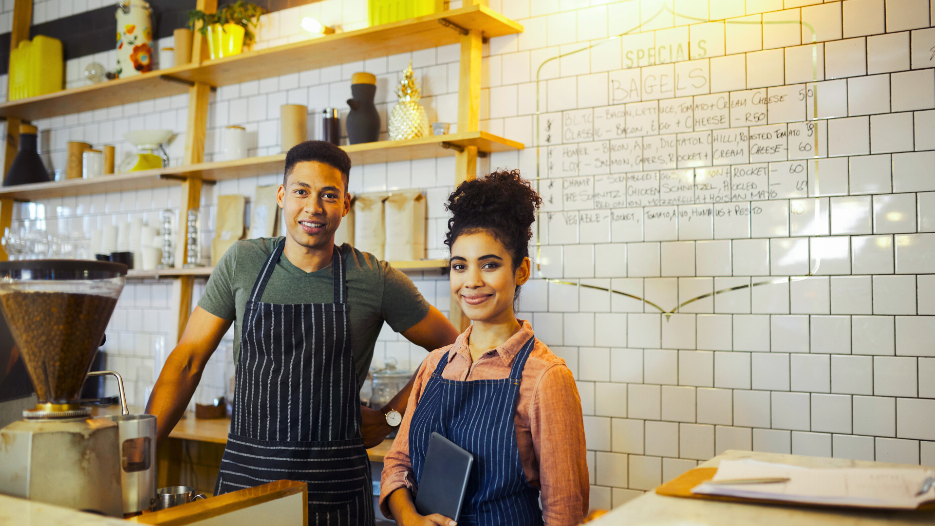 A man and a woman are standing next to each other in a restaurant.