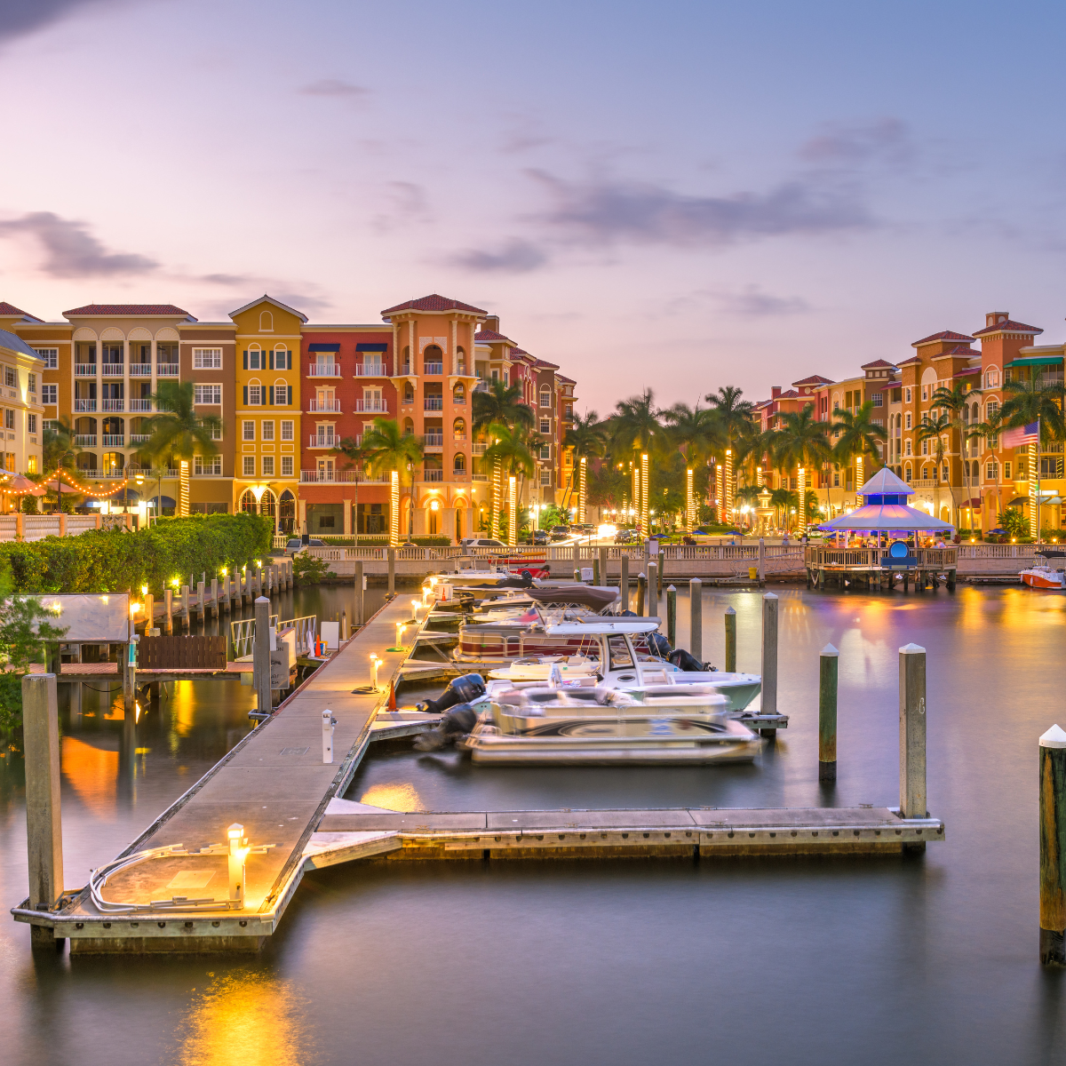 A marina with boats docked and buildings in the background