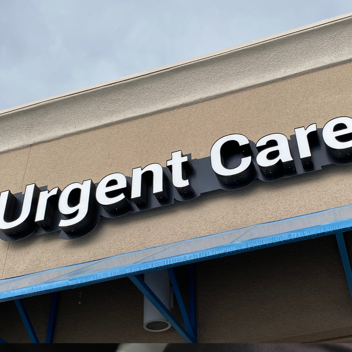 A sign on the side of a building that says urgent care