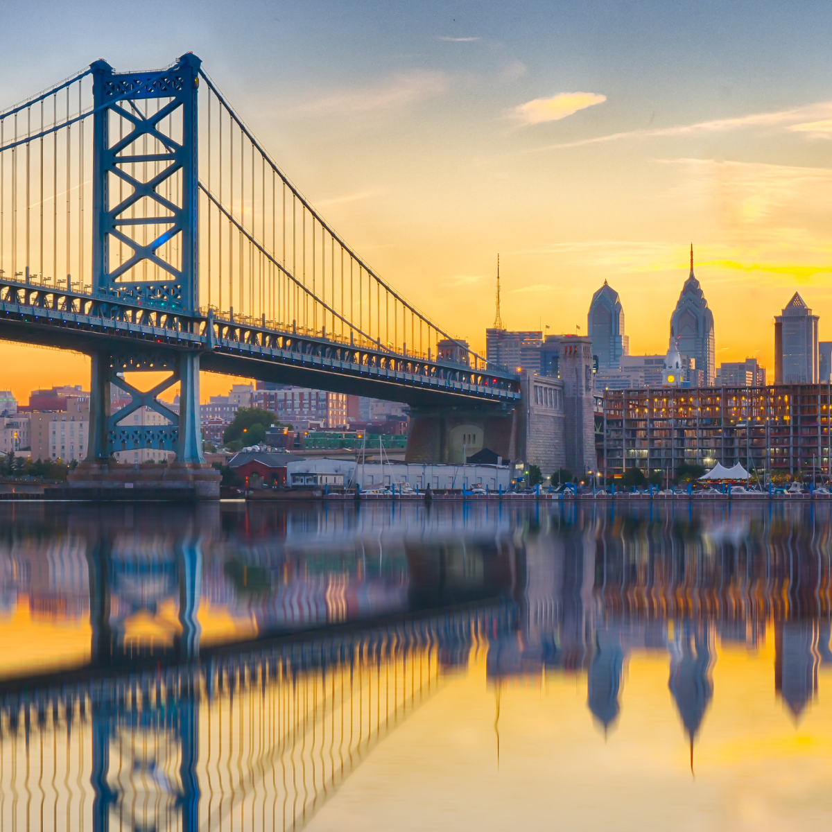 A bridge over a body of water with a city in the background