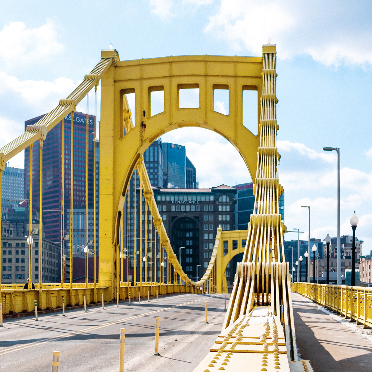 A yellow bridge with a city in the background