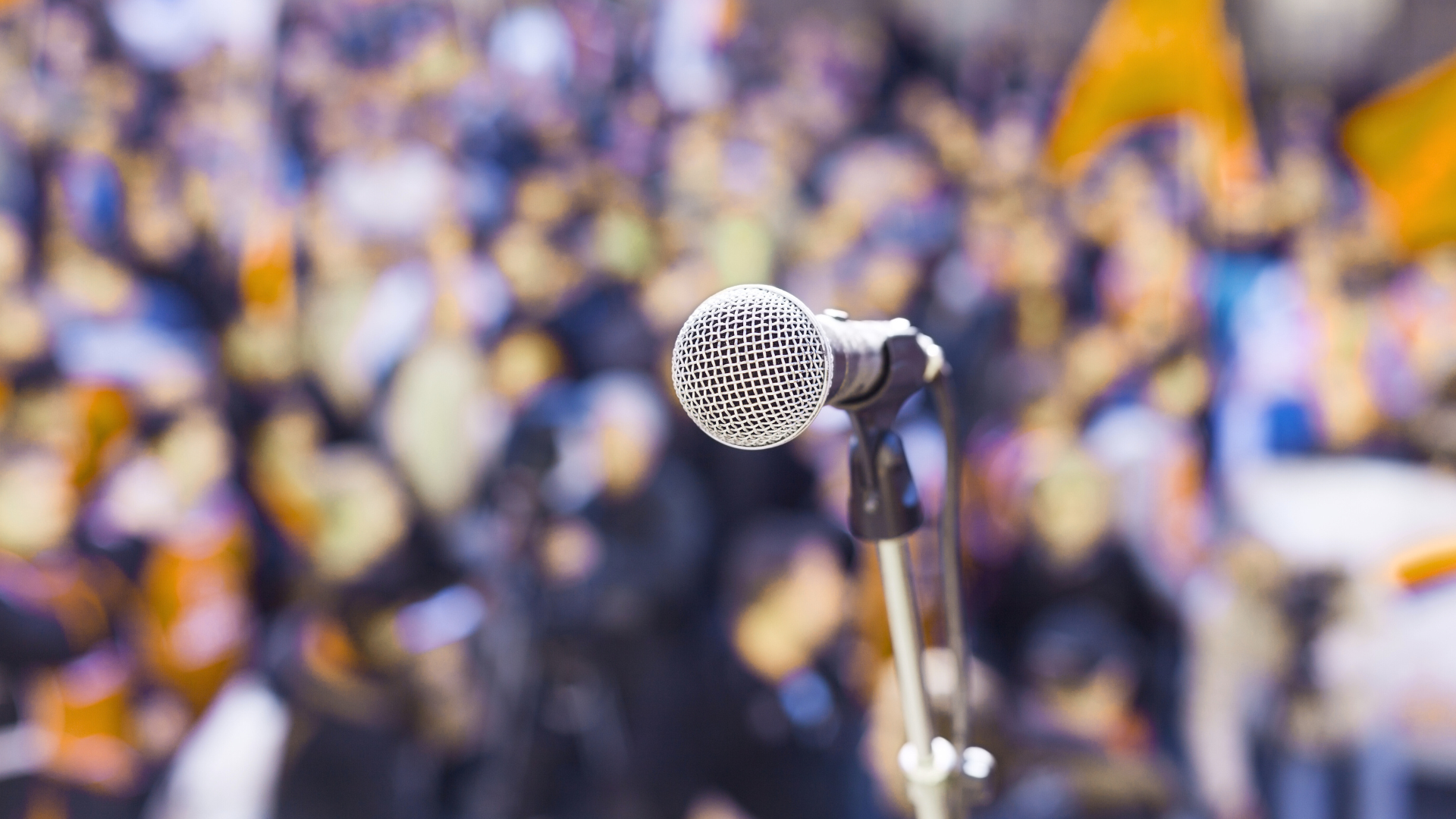 A microphone is sitting in front of a crowd of people.
