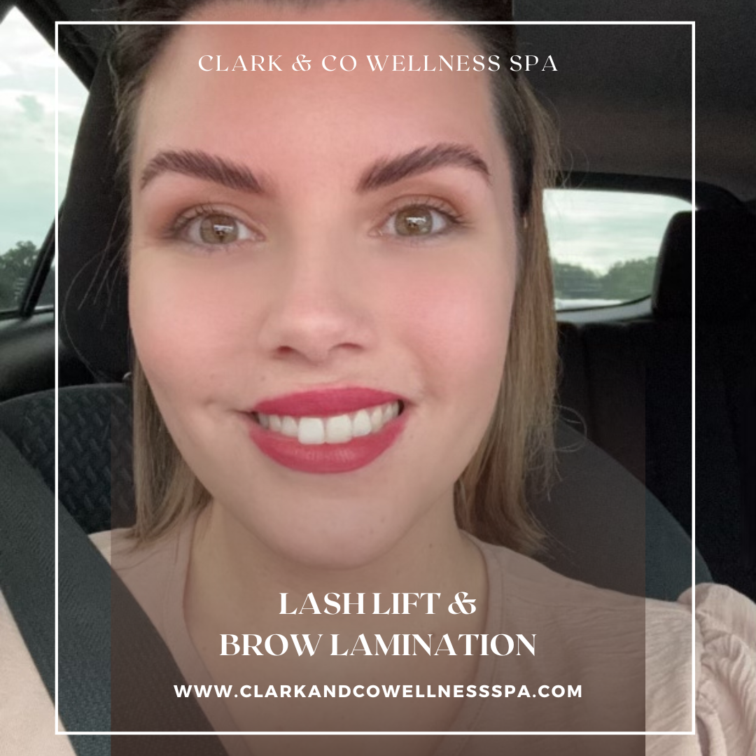 A woman is smiling in a car while wearing red lipstick