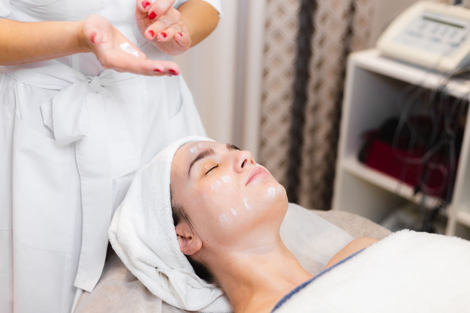 A woman is getting a facial treatment in a spa.