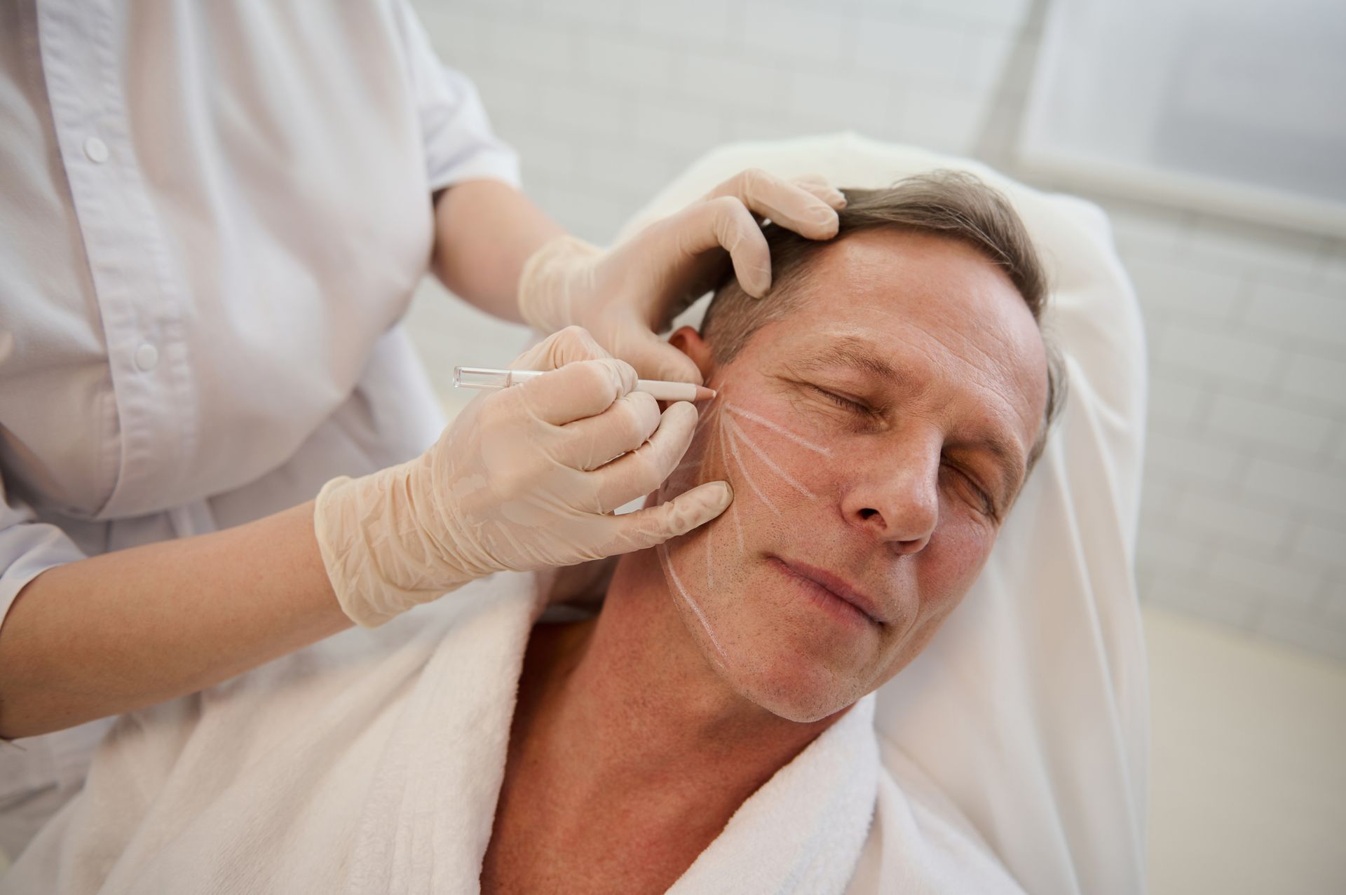 A man is getting a botox injection in his face.