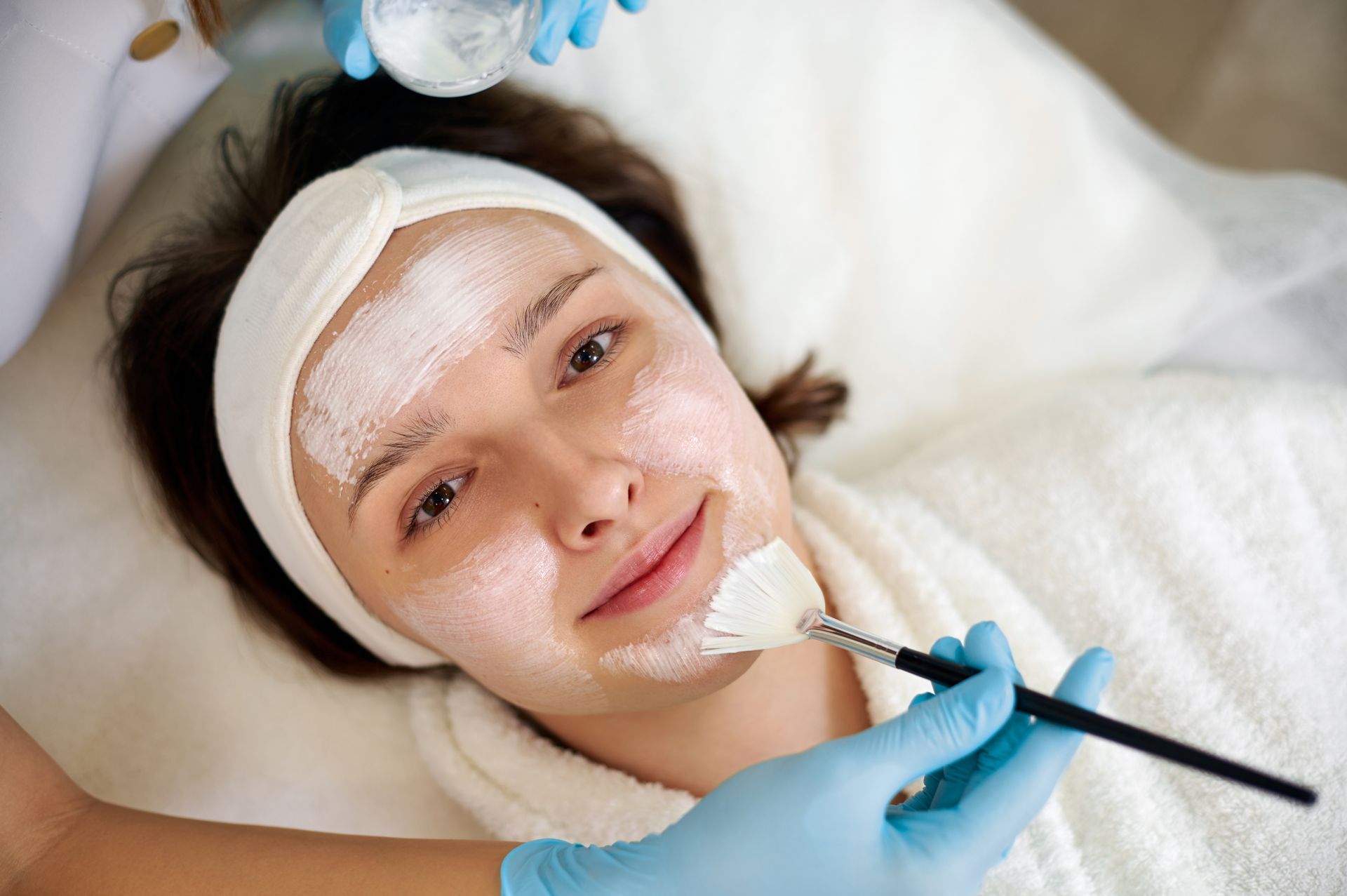 A woman is getting a facial treatment at a beauty salon.