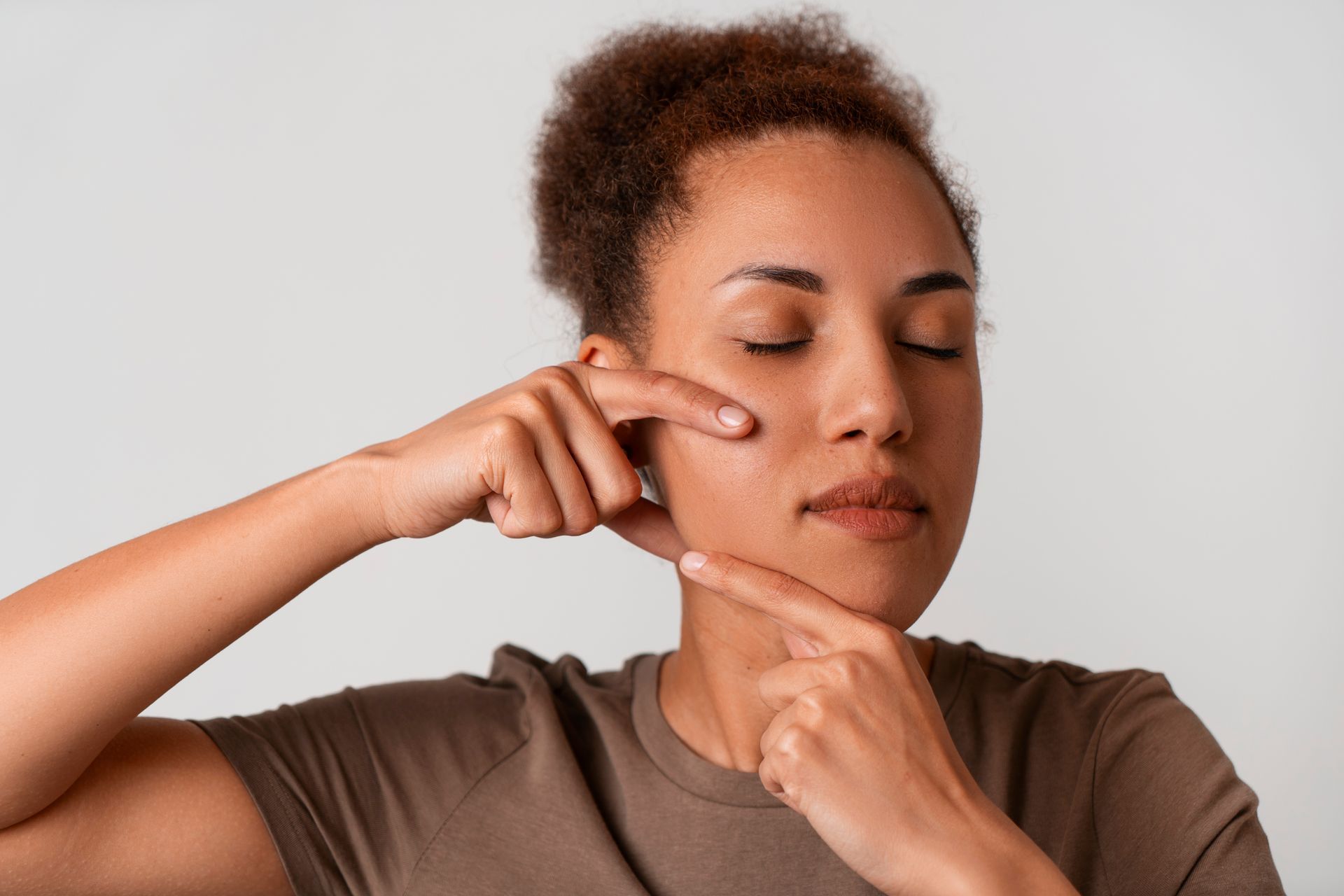 A woman is covering her ears with her hands.