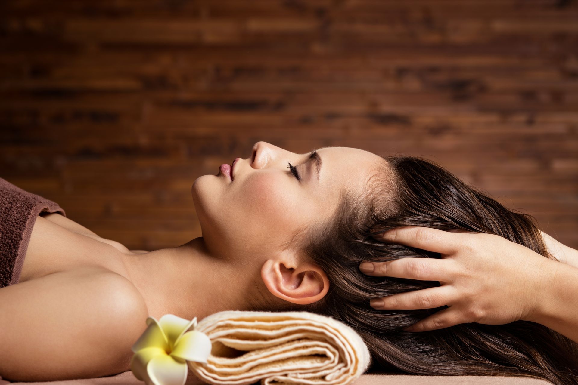 A woman is getting a head massage at a spa.