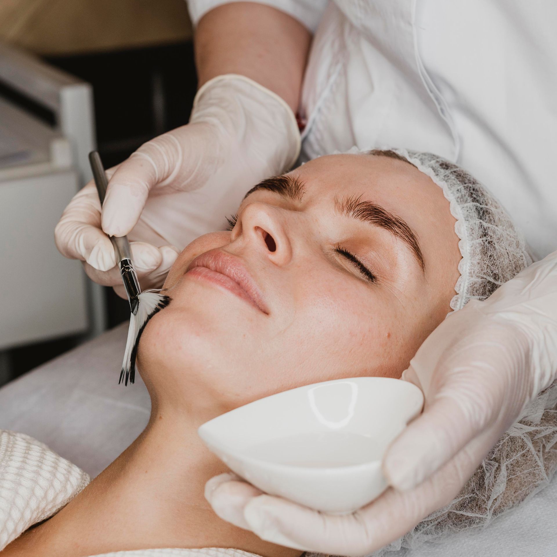 A woman is getting a facial treatment at a spa