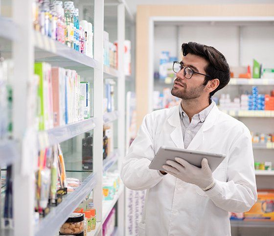 Man Using a Digital Tablet to Do Inventory in a Pharmacy — Crete, NE — Ken's Pharmacy