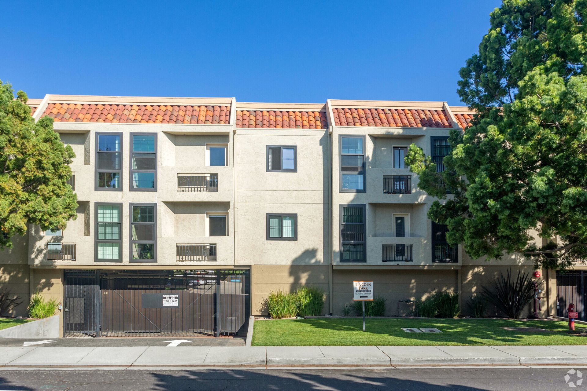 A large apartment building with a parking garage in front of it