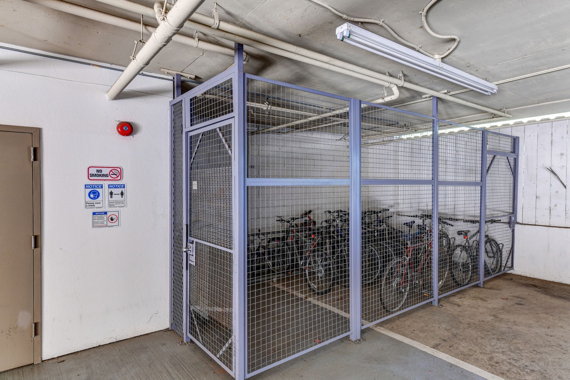 A cage filled with bicycles in a warehouse.
