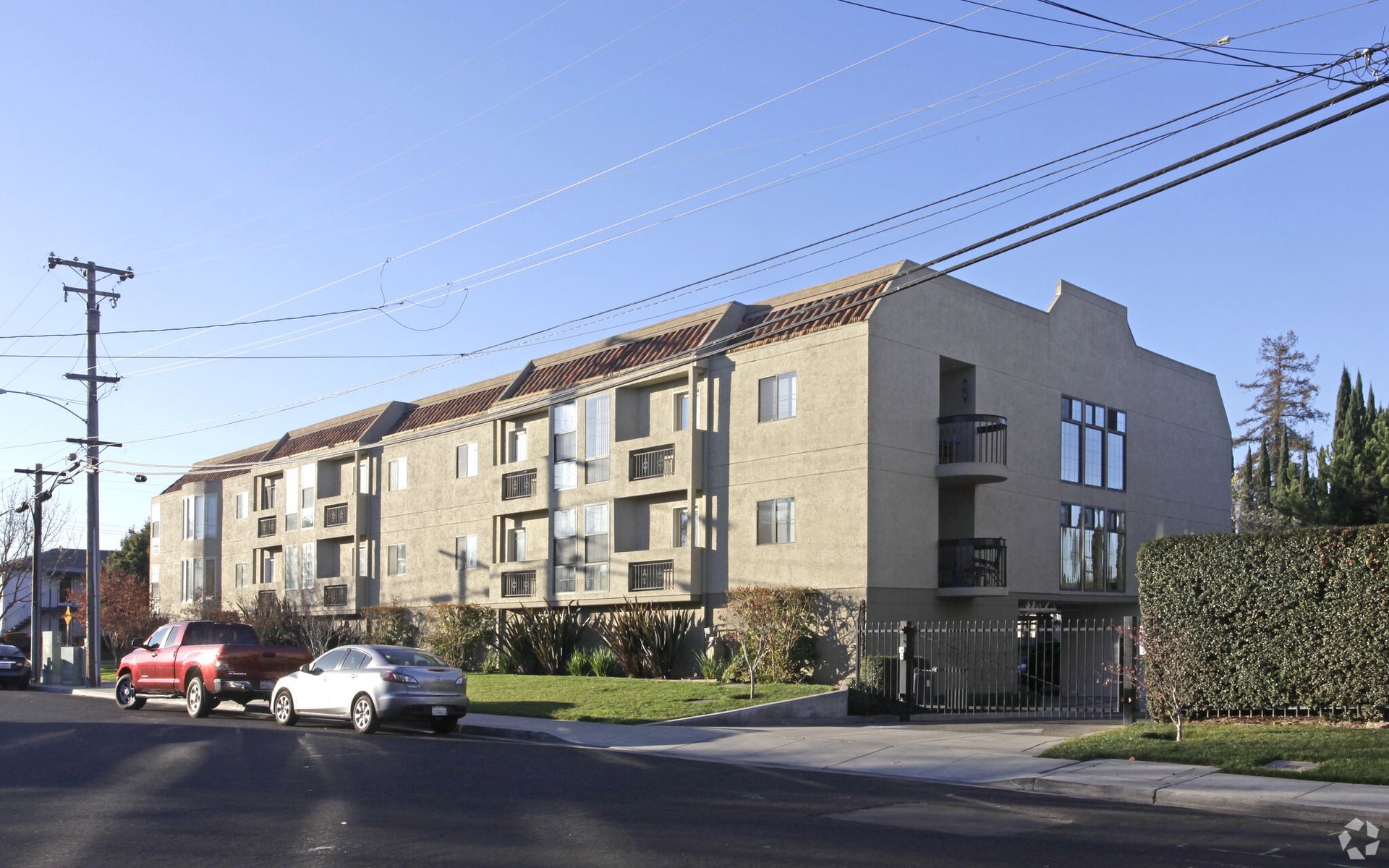A large apartment building with cars parked in front of it