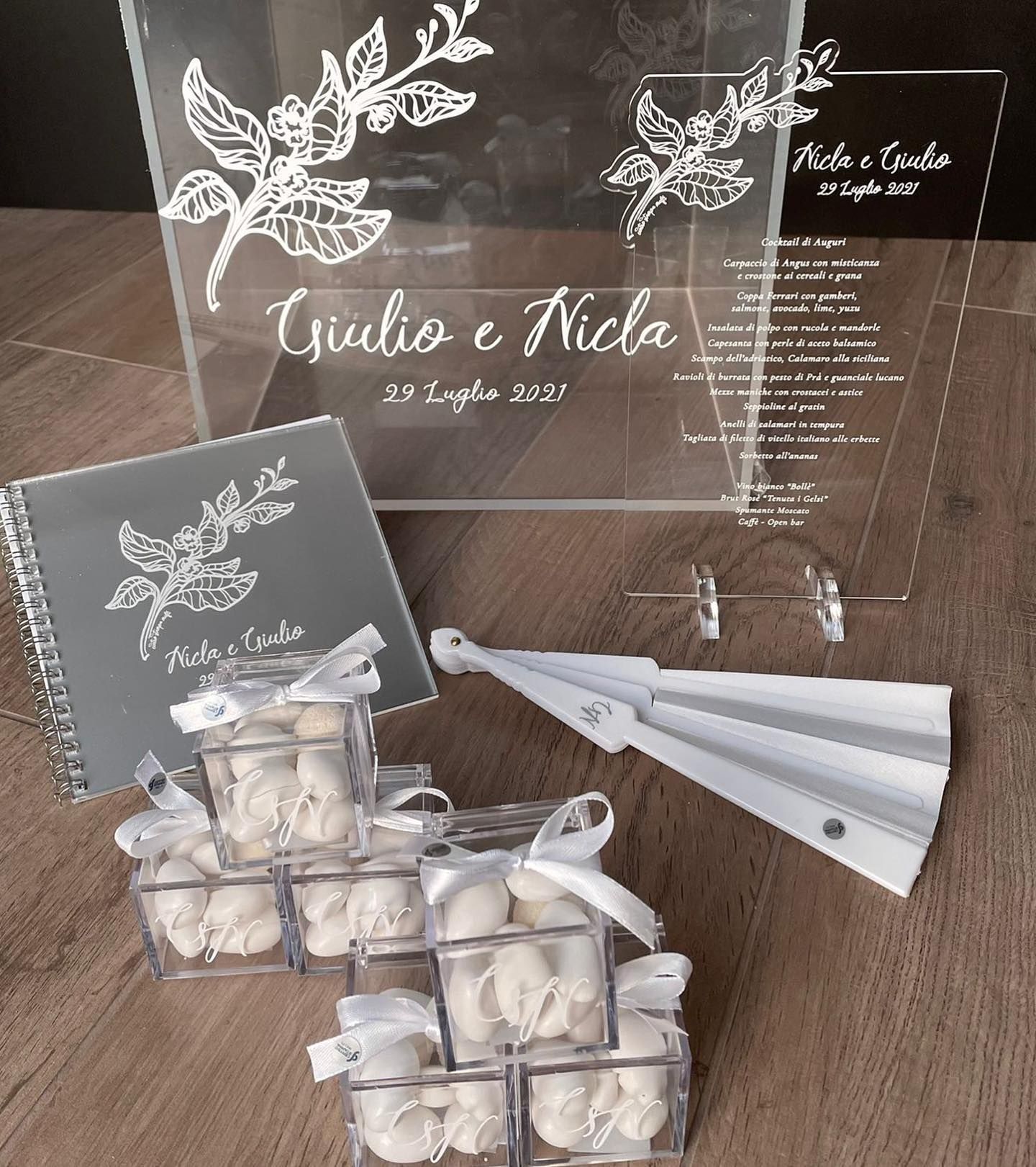 Decorazioni per matrimoni: cartelli in acrilico trasparente, bomboniere in scatole, libro degli ospiti e ventaglio.