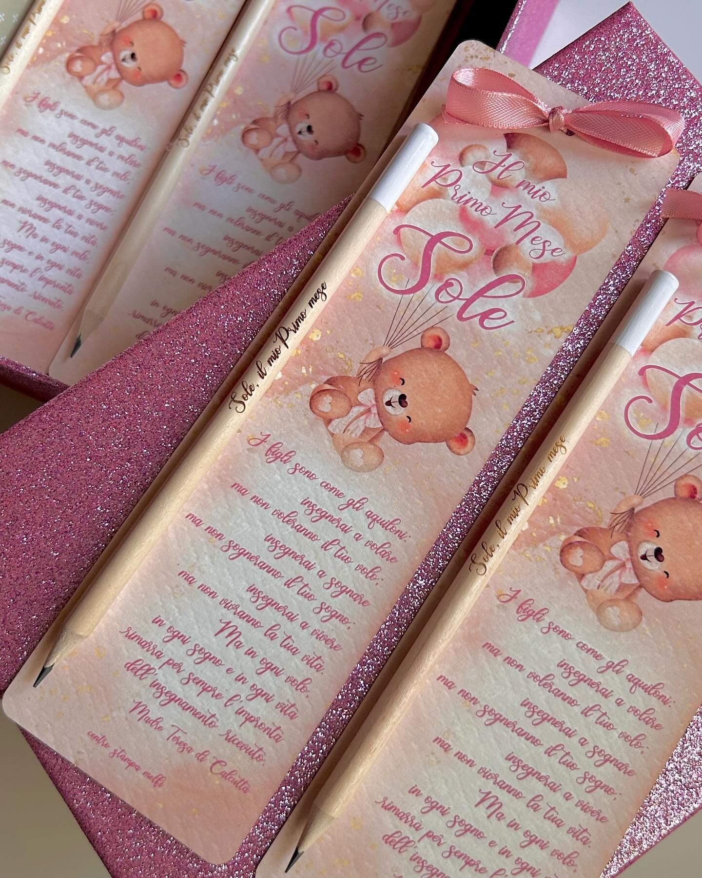 Segnalibri rosa con illustrazioni e testo di orsacchiotti, abbinati a matite e una scatola glitterata.